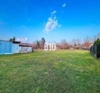 A plot of land near a family house in Sľažany with metal structures and a grassy area.