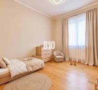 Children's room with a bed, armchair, and dresser, with a wooden decor floor.