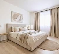 A bright bedroom with neutrally toned textiles and a wood-patterned floor in a family house.