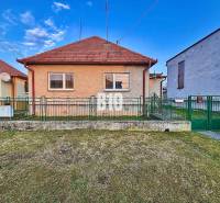 A family house in Sľažany with a front garden and a sloped roof between neighboring buildings.