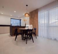 Dining nook with a window, curtains, and chairs in a family house with soft lighting.