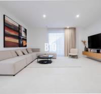 Living room with a comfortable sofa, large television, and modern art on the wall.