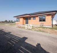 A family house under construction in Veľký Lapáš with a simple facade on an unkempt plot.