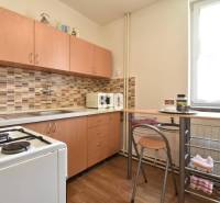 A kitchen in a family house with wooden furniture and a mosaic on the wall.