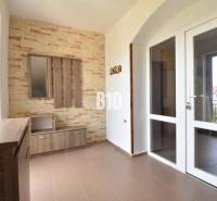 Interior of a family house with a coat rack wall and glass doors leading to the balcony.