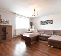 Living room in a family house with a sofa, wooden furniture, and wall decorations.