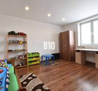 Children's room in a family house with wooden flooring and toys on the shelf.