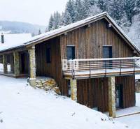 A snow-covered cottage in Horná Mariková surrounded by forest and beautiful winter nature.
