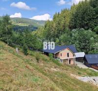 A family house situated in a valley with forests and hills. Charming natural scenery.
