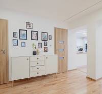 Interior of a family house with a wooden decor floor, white furniture, and decorations.