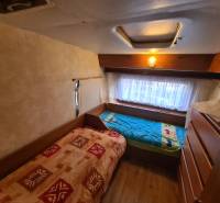 Two beds in a cozy cabin room with a wooden decor floor.