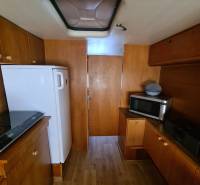 Interior of a cabin with wood-patterned flooring, a microwave, and a refrigerator.
