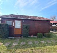 A wooden cottage in Štúrovo with a red tile roof and a stone pathway.