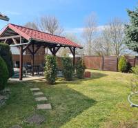 A cottage in Štúrovo with a gazebo, lawn, and trees; a peaceful garden for relaxation.