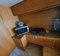 Cottage kitchen corner with wooden decor, microwave, and glass container.