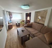 Living room with wood-patterned flooring, comfortable sofa, and television in a cabin.