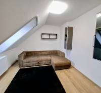 Living room with wood-patterned flooring in a three-room apartment.