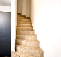 A staircase in a 3-room apartment with tiles and a transition to a floor with a wood decor.