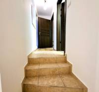 Hallway of a 3-room apartment with ceramic stairs and wooden doors.