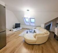 Living room with a cream sofa, wood-patterned floor, and a television in a 3-room apartment.