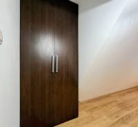 A wardrobe with double doors, a floor with wooden decor in a three-room apartment.