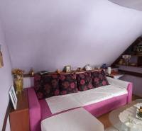 Purple room in a family house with a pink sofa and decorative pillows.