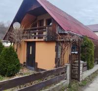 A family house in Horelica in Čadca with a red roof and a wooden fence.