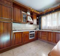 A kitchen with wooden decor, white curtains, and ceramic tiles in a 5 or more room apartment.