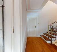 A hallway with a decorative glass panel, staircase, and flooring with a wood decor in a 5 or more room apartment.