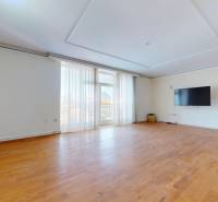 A spacious room in a 5 or more bedroom apartment with a wooden decor floor.