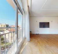 Wide windows, wooden decor flooring, TV on the wall, city view.