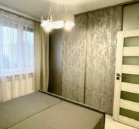 Bedroom with a large bed, built-in wardrobe, and curtains in a 2-room apartment.