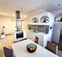 Elegant kitchen with an island, white cabinets, and wood-patterned flooring, 2-room apartment.