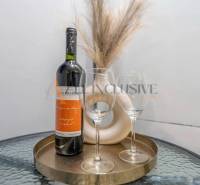 A bottle of wine and glasses on a round table in a 3-room apartment.