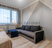 Living room with sofas and wooden decor flooring in a three-room apartment.