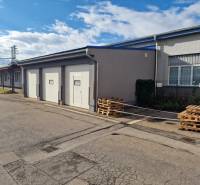 A building with garage doors, storage spaces near the railway track in Žilina.