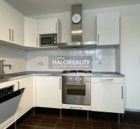 A kitchen in a 3-room apartment with white cabinets and stainless steel appliances.