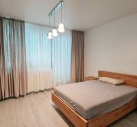 A bright bedroom with wooden furniture and a wooden decor floor in a 3-room apartment.