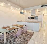 Dining area in a 3-room apartment with glossy tiles and a glass table.