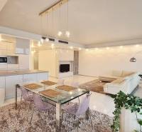 Living room in a three-room apartment with white furniture and a glass table.