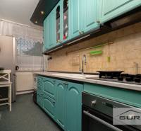 A kitchen with green cabinets, an oven, and a window in a 3-room apartment.