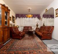 A classic living room in a three-room apartment with wooden furniture and a carpet.