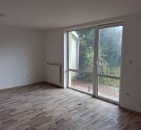 A room with a wooden decor floor in a family house and a view of the garden.