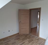 A room in a family house with a wooden decor floor and wooden doors.