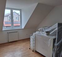 A room in a family house with a window, a heating element, and a floor with a wooden decor.