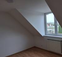 An attic room with a window and a wooden decor floor in a family house.