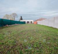 A garden next to a family house in Mojmírovce on the Fourth Row with panel fencing.