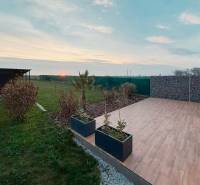 A family house on the Fourth Row in Mojmírovce with a terrace and a view of the garden at sunset.