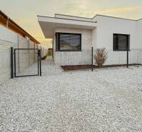 A family house on the Fourth Row in Mojmírovce with a stone front garden and a modern fence.