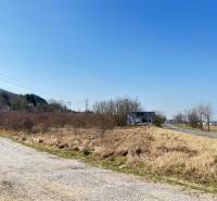 Commercial land in Bratislava - Devínska Nová Ves, next to the road, bordered by shrubs.